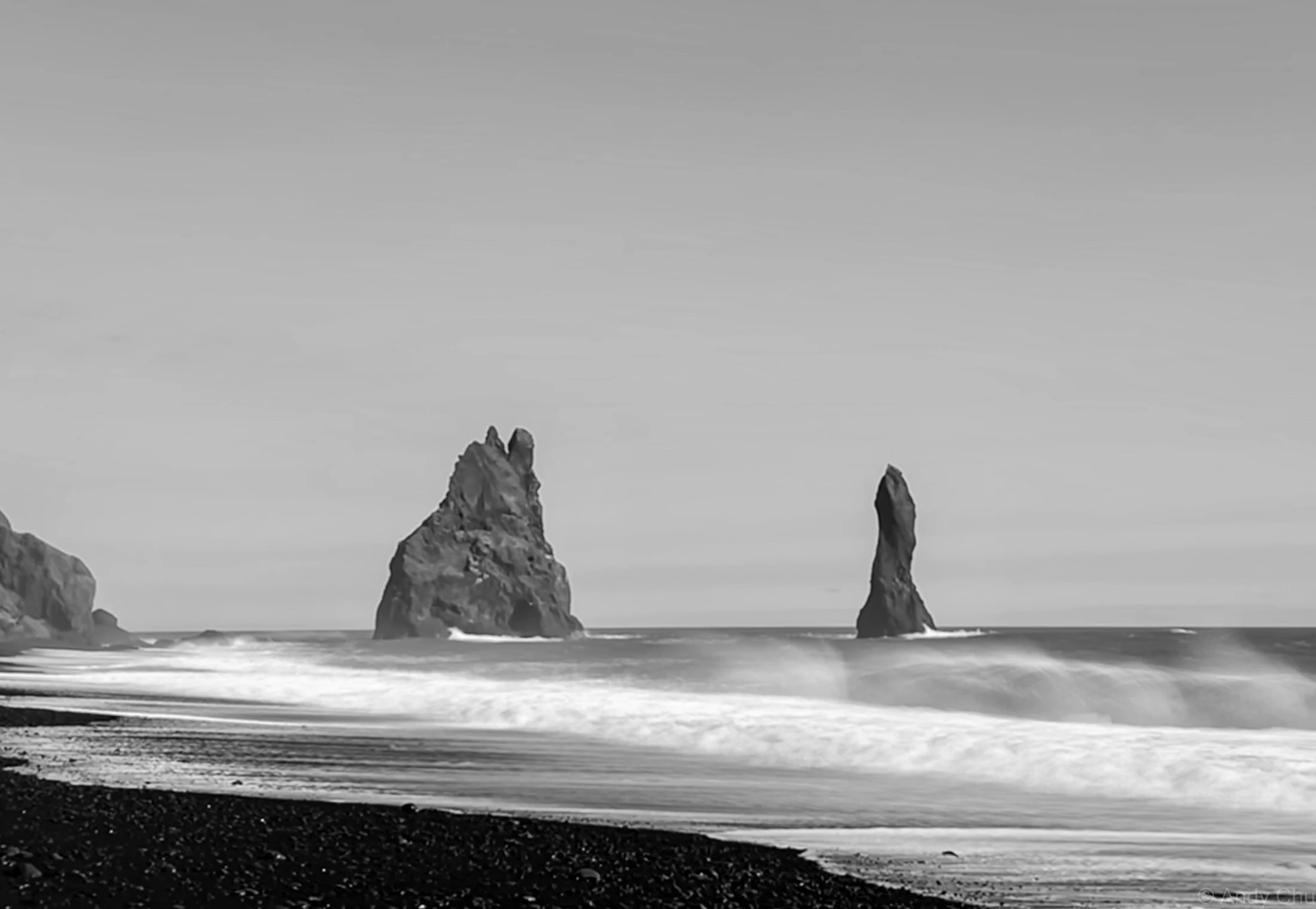 Black-and-white seascape with waves and tall sea stacks