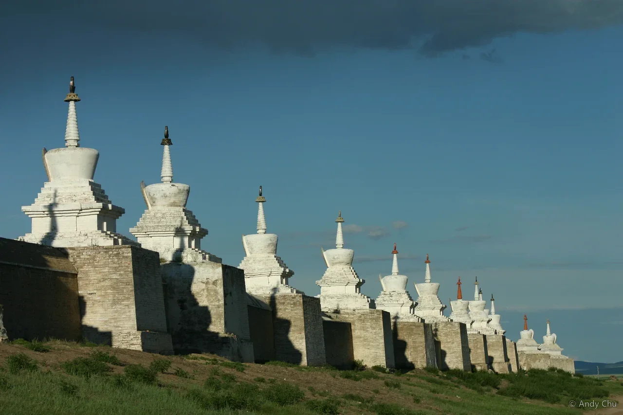 A row of white stupas beneath a blue sky